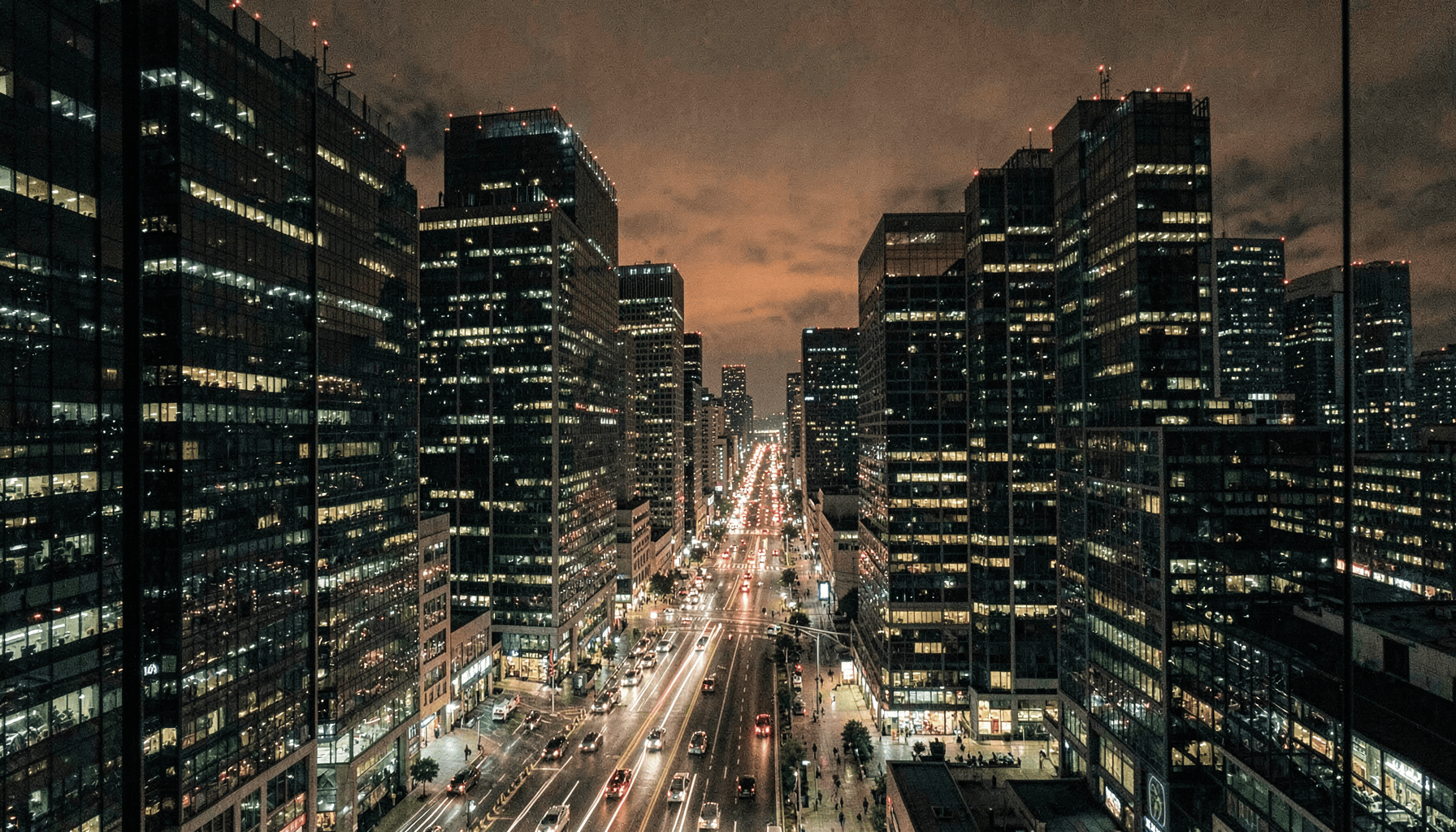 Distrito financiero de noche con torres de oficinas iluminadas y tráfico en la avenida, ilustración del artículo sobre perímetro de red