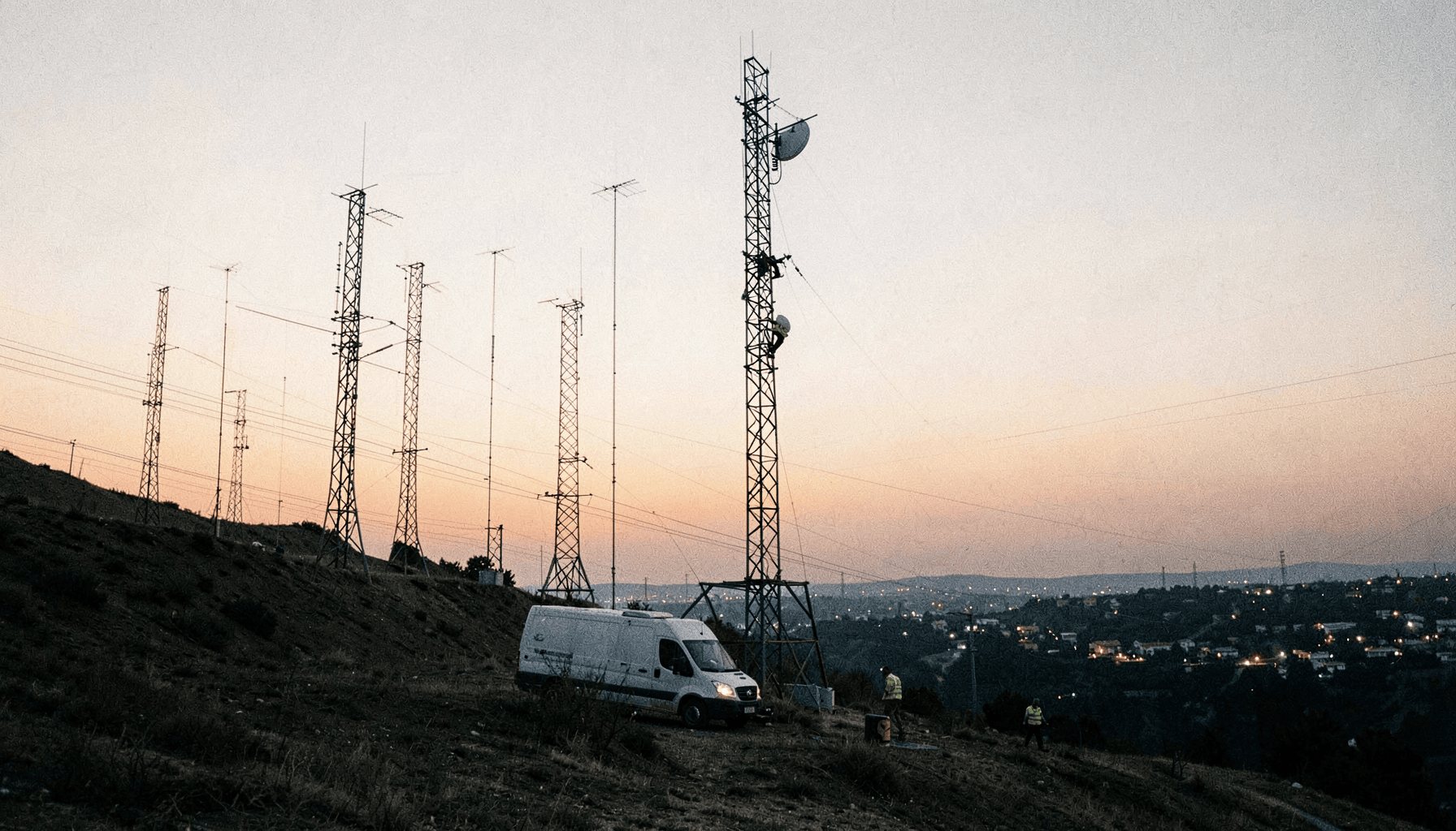 Torres de telecomunicaciones en una loma al atardecer con un técnico subiendo, ilustración del artículo sobre exposición de interfaz de administración