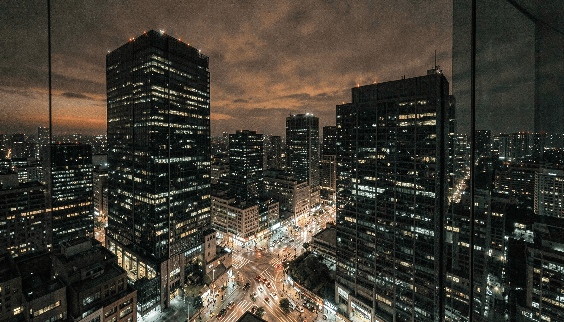 Distrito financiero de noche con torres de oficinas iluminadas y tráfico en la avenida, ilustración del artículo sobre inyeccion de comandos